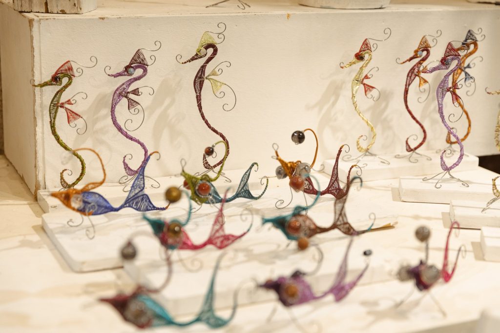 Caballitos de mar de alambre de colores sobre la mesa del taller